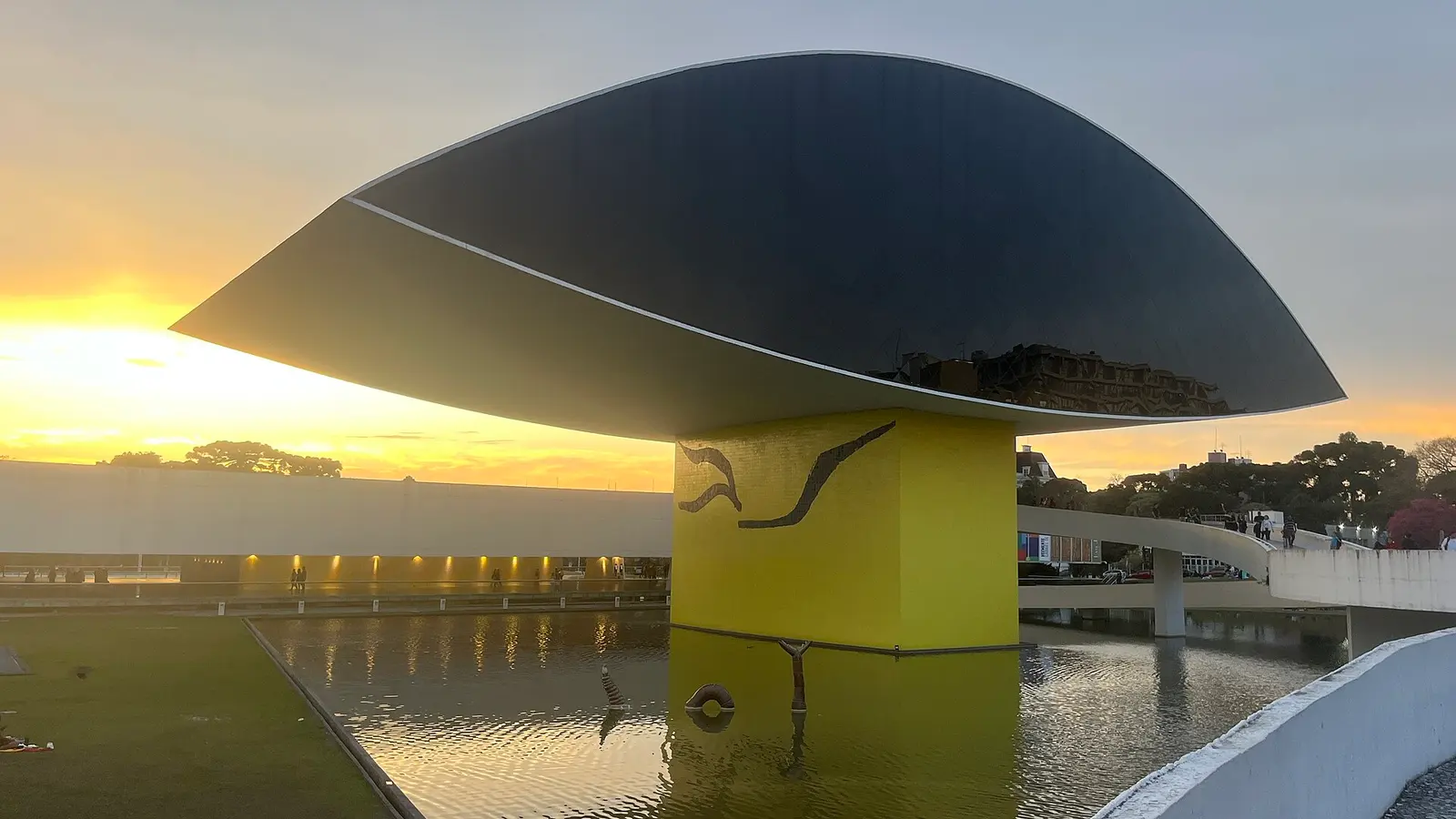 O Olho do Museu Oscar Niemeyer ao entardecer, refletido no espelho d'água